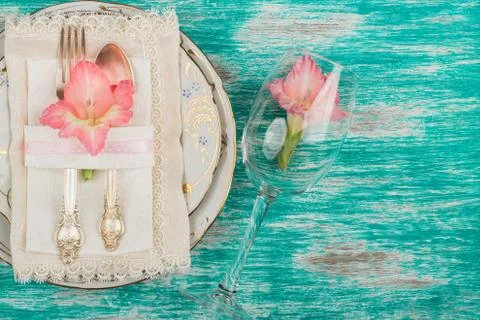 Tableware and silverware with light pink gladiolus on the azure background 写真素材