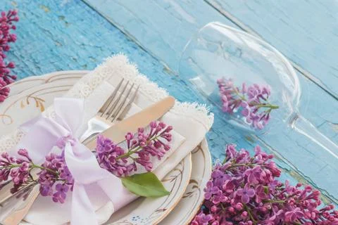 Tableware and silverware with violet lilac on the wooden backgro Stock Photos