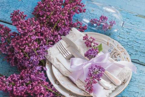 Tableware and silverware with violet lilac on the wooden backgro Stock-Fotos