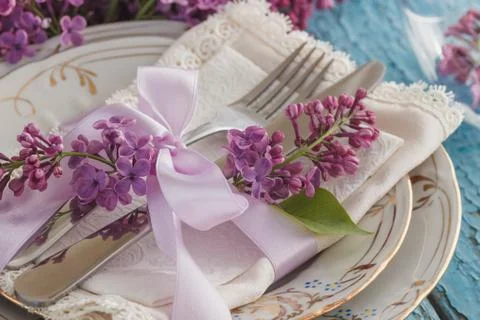 Tableware and silverware with violet lilac on the wooden background Stock Photos