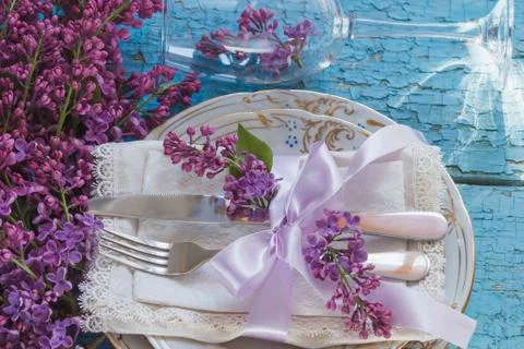 Tableware and silverware with violet lilac on the wooden background Stock Photos