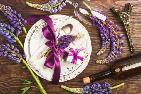 Tableware with violet lupinus and silverware Stock Photos