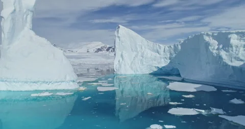 Tabular icebergs melt at turquoise ocean bay aerial. Huge high ice glacier Stock Footage