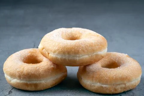 Tack of three classic sugar donuts on a grey rustic background Stock Photos