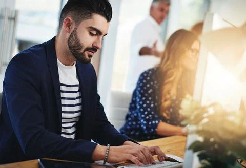 Tackling big problems. Cropped shot of a young designer working at his desk with Stock Photos