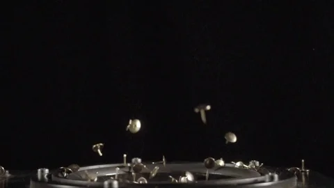 Tacks dancing in a speaker in slow motion in front of a black screen Stock Footage 81821861