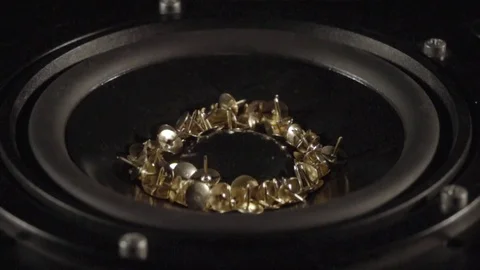 Tacks dancing in a speaker in slow motion close up Stock Footage 81821918
