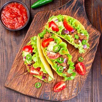 Taco with ground beef meat,  mashed avocado, tomato, lettuce, red onion 写真素材