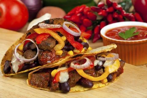 Taco shells filled with meat sauce and beans Foto stock