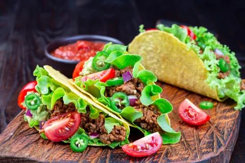 Taco shells with ground beef meat, mashed avocado, tomato, lettuce, red onion 스톡 사진