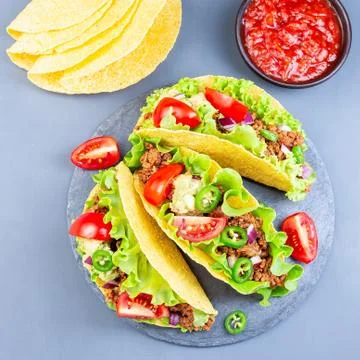 Taco shells with lettuce, ground beef meat,  mashed avocado, tomato 스톡 사진