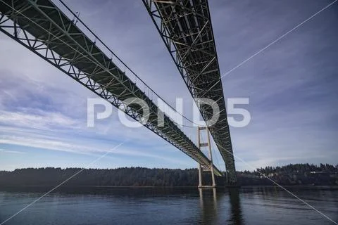 The Tacoma Narrows Bridges from the water surface, looking West toward Point Fos Stock Photos