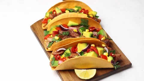 Tacos with pork, avocado, tomatoes, corn and onions. Mexican food. Stock Footage 167991004