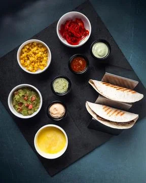 Tacos rest on a dark serving board 库存照片