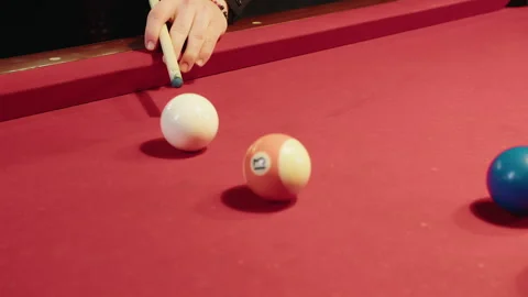Tactical cue nudges target ball across felt red table, close view of male hand Video stock 329192793