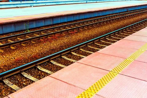 Tactile paving beside parallel train tracks 库存照片