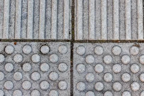 Tactile paving texture creating an accessible sidewalk surface Stock Photos