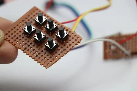 Tactile push buttons arranged on empty pcb for electronics prototyping Photos