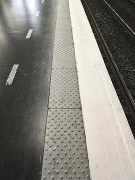 Tactile Warning Studs Pavement At Train Station Platform With RER Tracks Foto stock