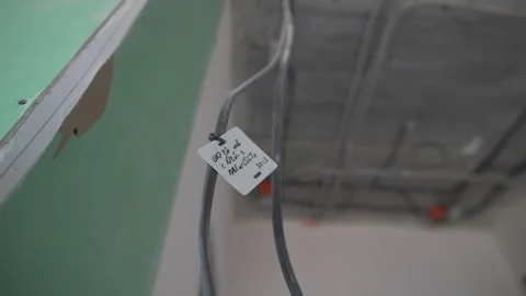 Tagged electrical wires hang from ceiling in incomplete hall Видео 310602702
