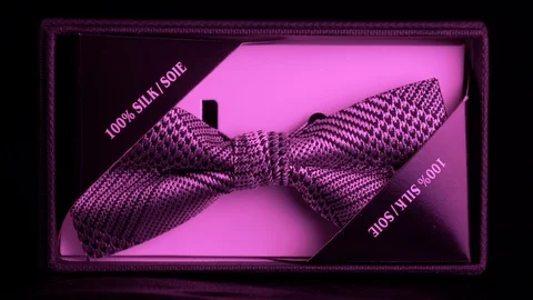 Tagged luxurious patterned silk bow tie in retail box - rich purple light 4k Stock Footage 98405080