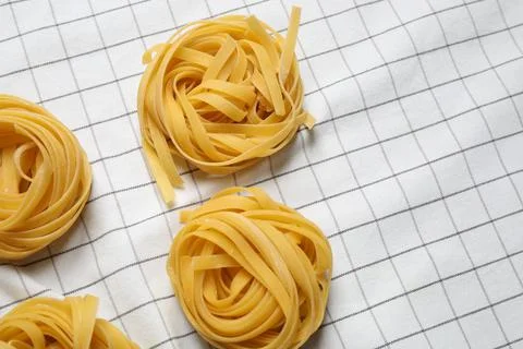 Tagliatelle pasta on white tablecloth, flat lay Stock Photos