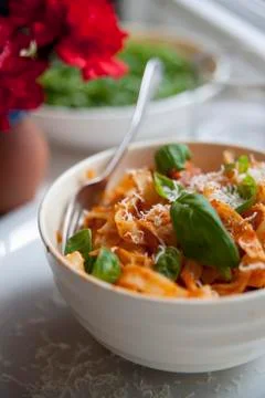 Tagliatelle with tomato sauce, chorizo, chillis, Parmasan and fresh basil Stock Photos