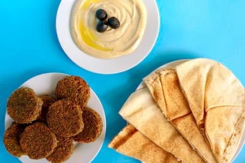Tahini, pita bread and falafel on blue background, top view. Egipt food. Stock Photos