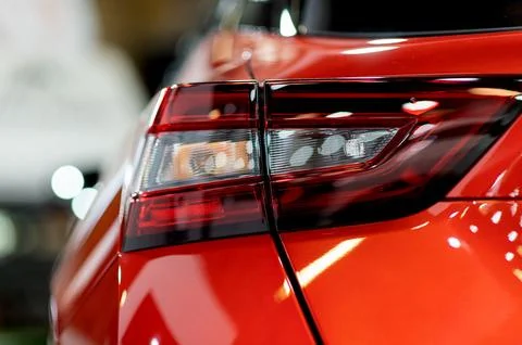 Tail light of nice and new orange sport suv car in modern garage. Stock Photos