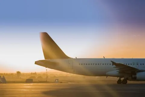 The tail of the plane in the rays of the rising sun Stock Photos