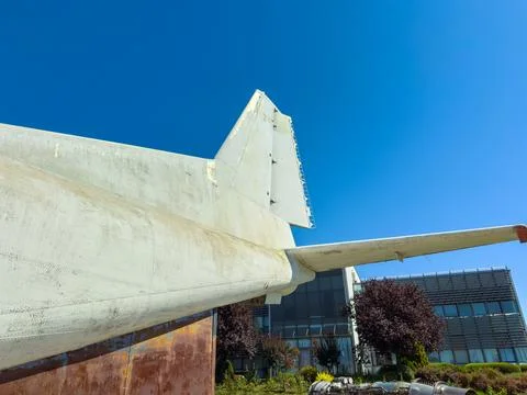 A tail section of an old airplane stands on display at an aerospace museum. T Stock Photos