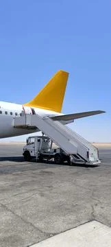 The tail section of a passenger plane with a ramp on an airport apron 스톡 사진
