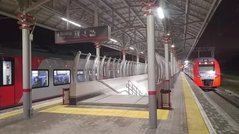Tail of train leaving illuminated empty platform Stock Footage 299615021