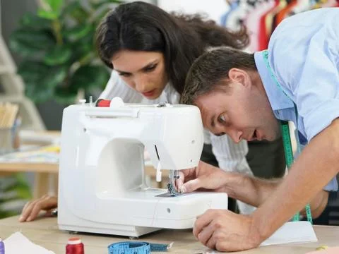 The tailor is checking the authenticity of the sewing machine. Stock Photos