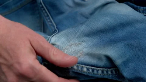 Tailor checks quality of darning holes rubbed between legs on women's jeans. Stock Footage 197397407