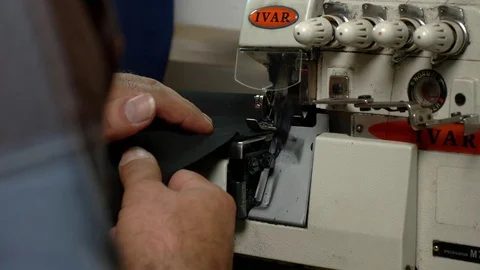 Tailor cuts the bottom of the fabric with a machine. Slow-motion Video stock 73359107