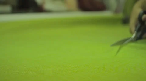 A tailor cuts a large green fabric. Stock Footage 24605311