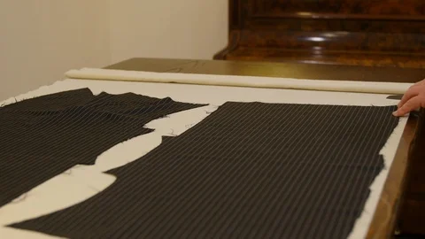 The tailor cuts a sewing pattern from the domette material with scissors. this Stock Footage 127233429