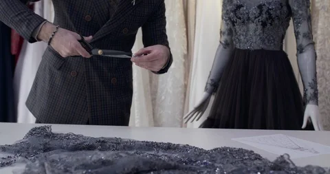 The tailor cutting the fabric during designing a dress in atelier Vídeo Stock 129034140