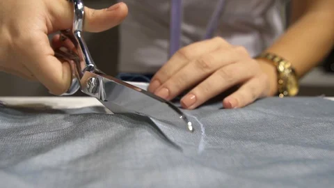 Tailor is cutting fabric with scissors Stock-Footage 99035609