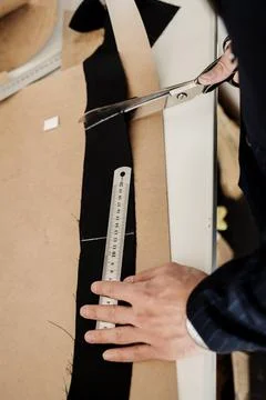 Tailor cutting fabric with scissors Stock Photos