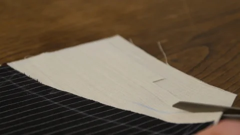 Tailor cutting fabric with shears at table in atelier, closeup of tailoring Stock Footage 127252093