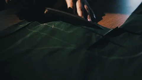 Tailor cutting fabric using large scissors or shears as he follows the chalk Stock Footage 86450150