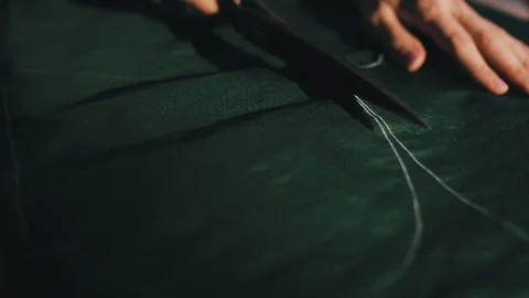 Tailor cutting fabric using large scissors or shears as he follows the chalk 스톡 동영상 86450259