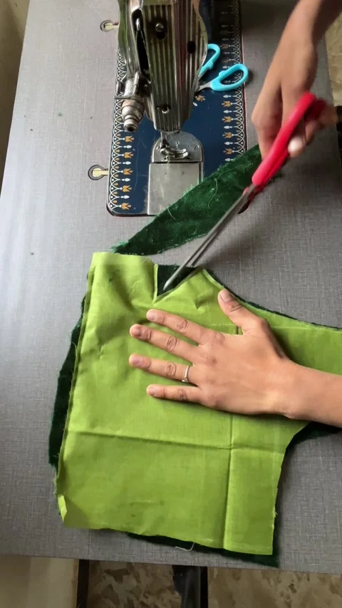 Tailor Cutting Green Fabric with Scissors Near Sewing Machine – Garment Making Stockbeeldmateriaal 329460257