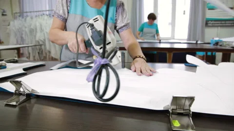 Tailor cutting the patterns with electric saw Stock Footage 62351291
