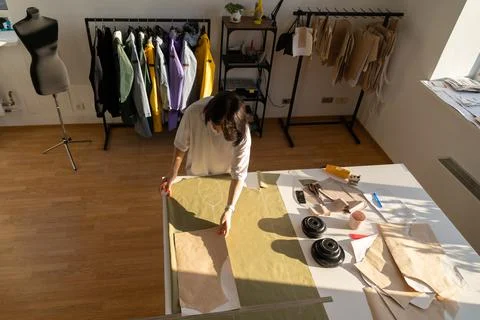 Tailor cutting textile from paper pattern. Fashion designer draft on fabric work Stock Photos