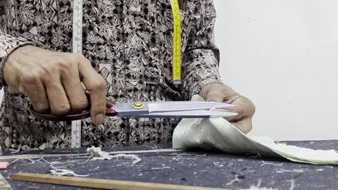 Tailor cutting white fabric with large scissors . Stock Footage 335084057