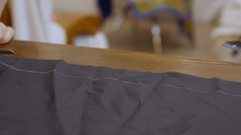 Tailor designer hands cutting lining fabric.  A lining reduces the wearing Stock Footage 127260546