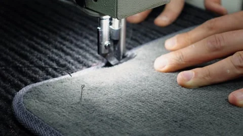 Tailor hand, electric sewing machine, stitches, edging, textile mat textile rugs Stock Footage 208221752